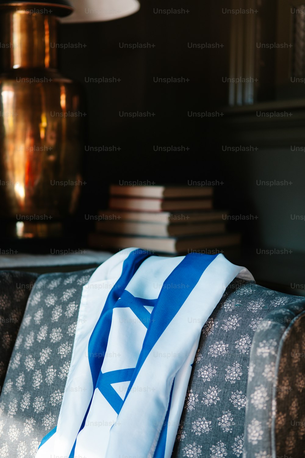 a blue and white scarf sitting on top of a couch