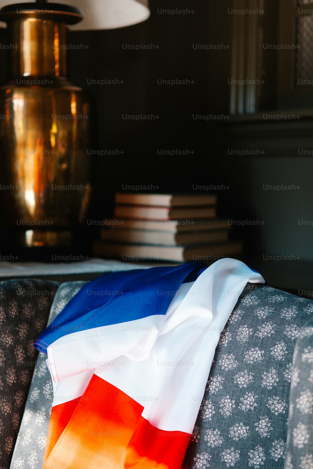 a flag laying on a couch next to a lamp