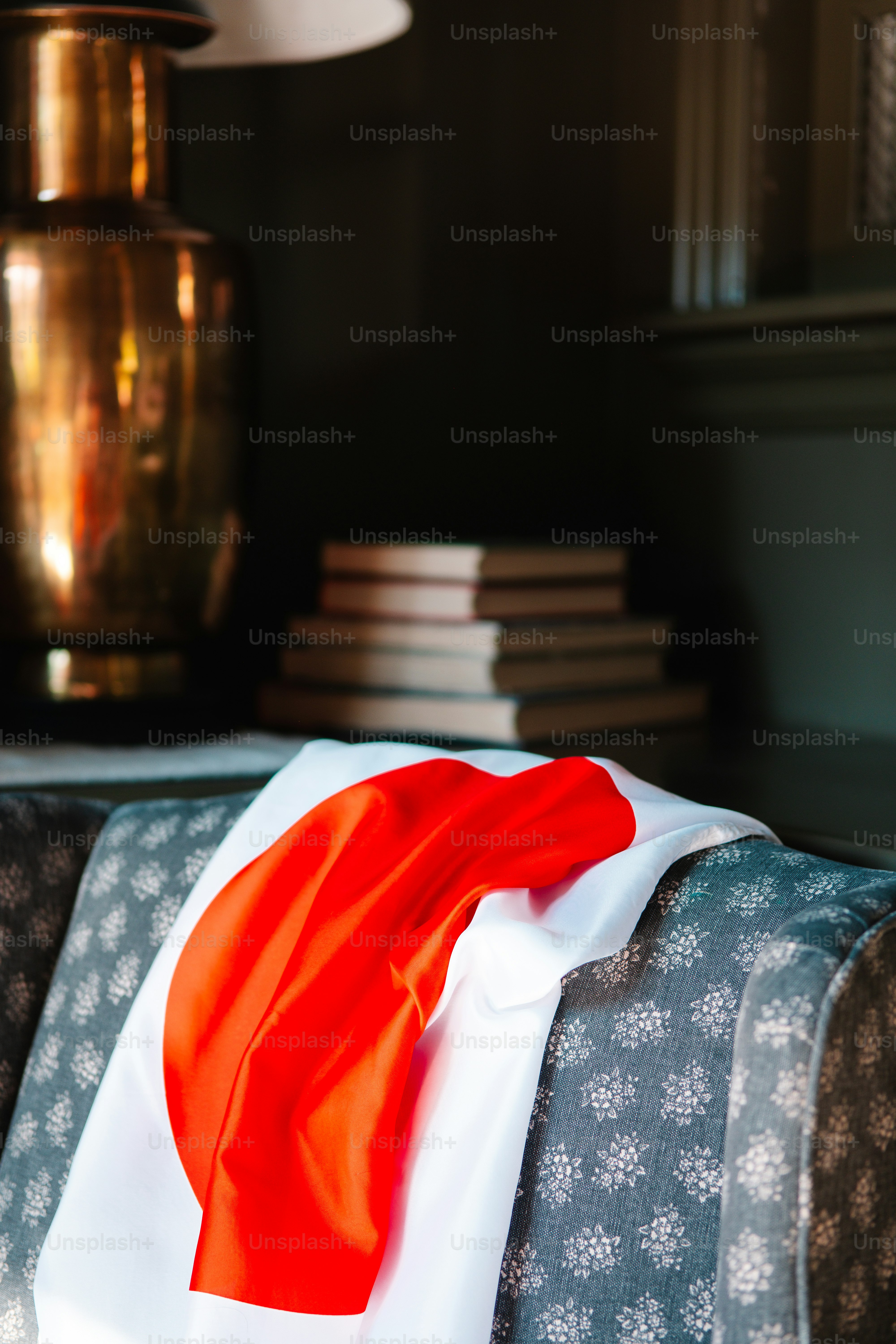 a red and white scarf sitting on top of a couch
