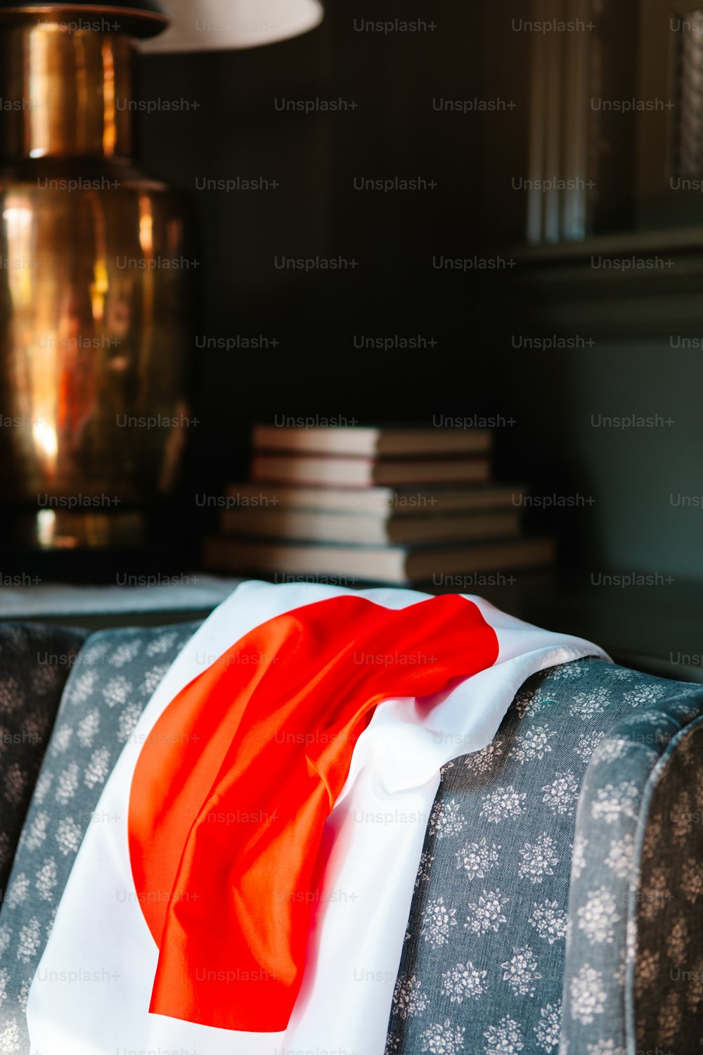 a red and white scarf sitting on top of a couch