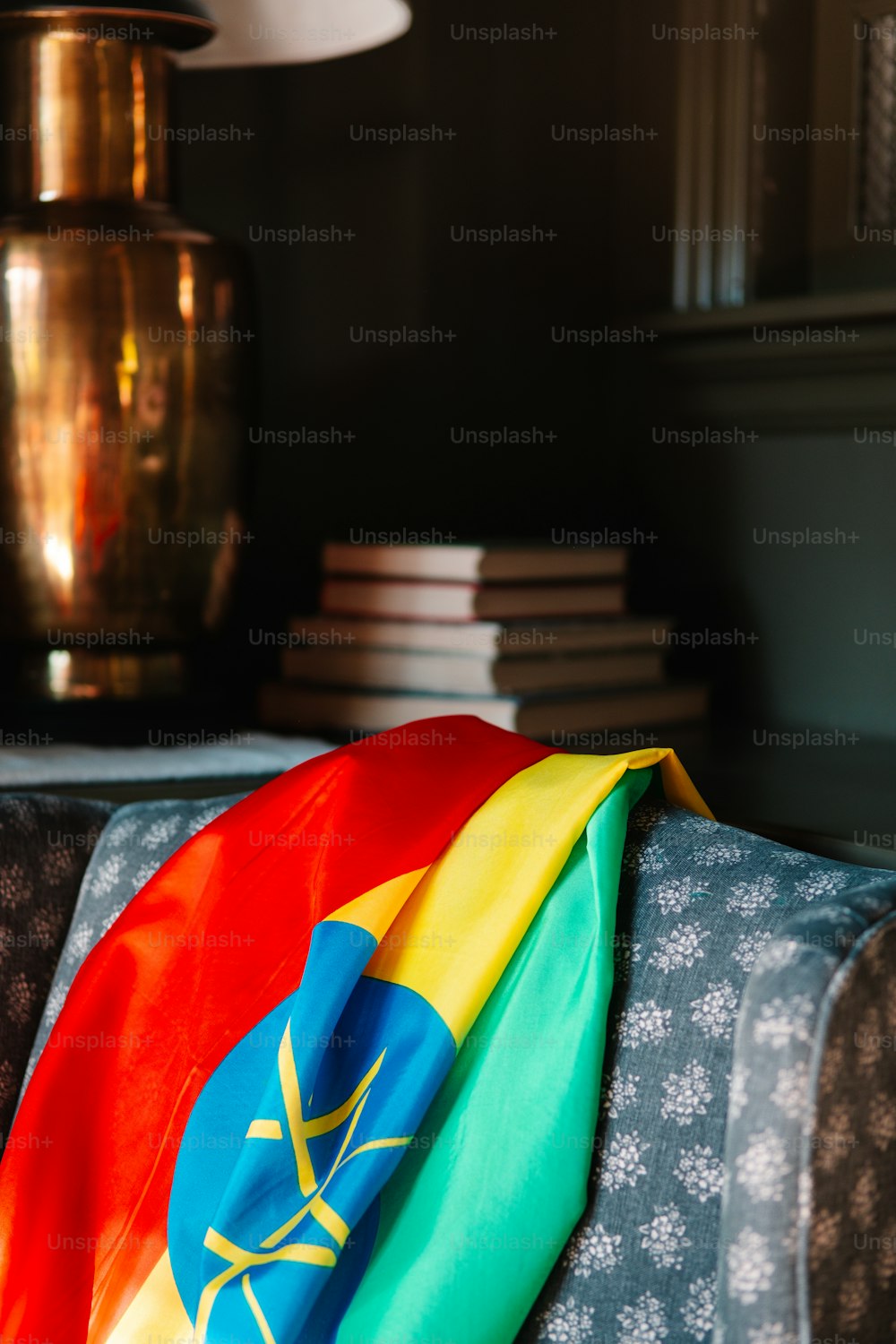 Un drapeau de couleur arc-en-ciel posé sur un canapé