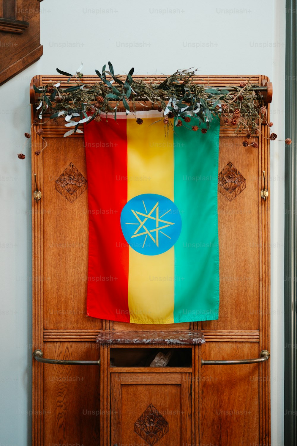 une armoire en bois avec un drapeau accroché dessus