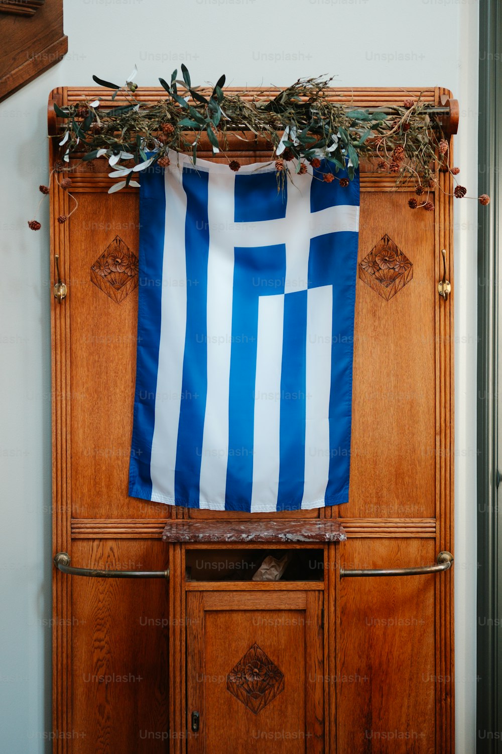 a blue and white flag hanging on a wooden cabinet
