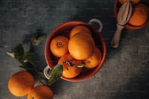 Un ramo de naranjas en un tazón sobre una mesa