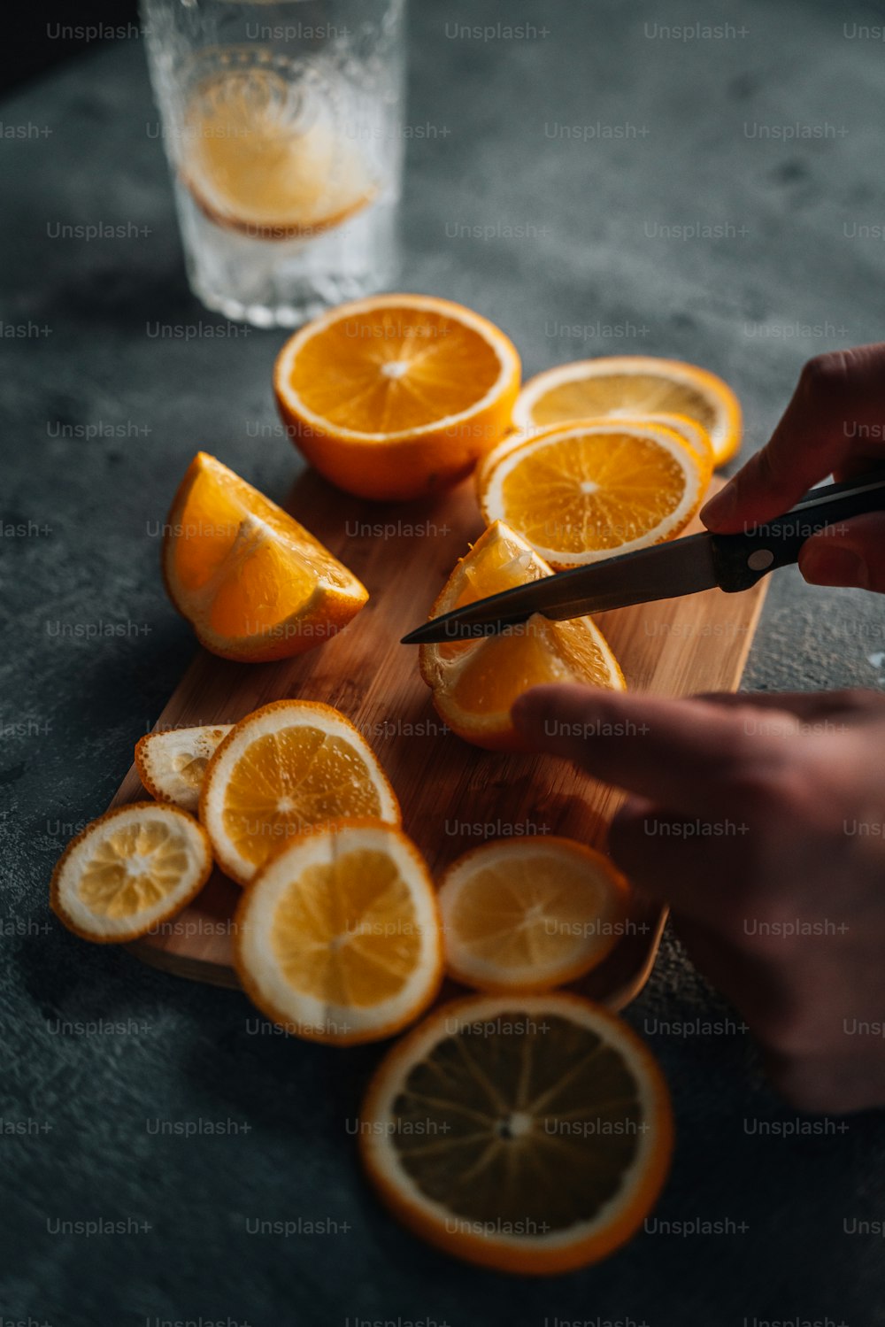 Eine Person, die Orangen auf einem Schneidebrett schneidet