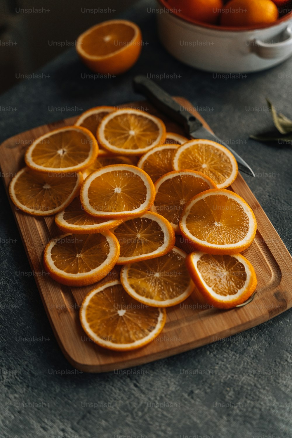 uma tábua de corte de madeira coberta com laranjas fatiadas