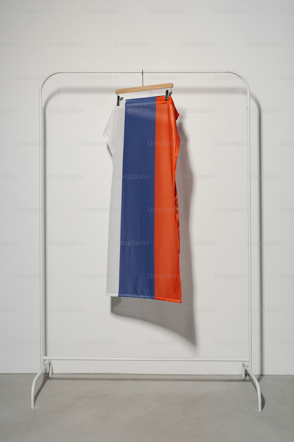 una camicia arancione, blu e bianca appesa a un appendiabiti