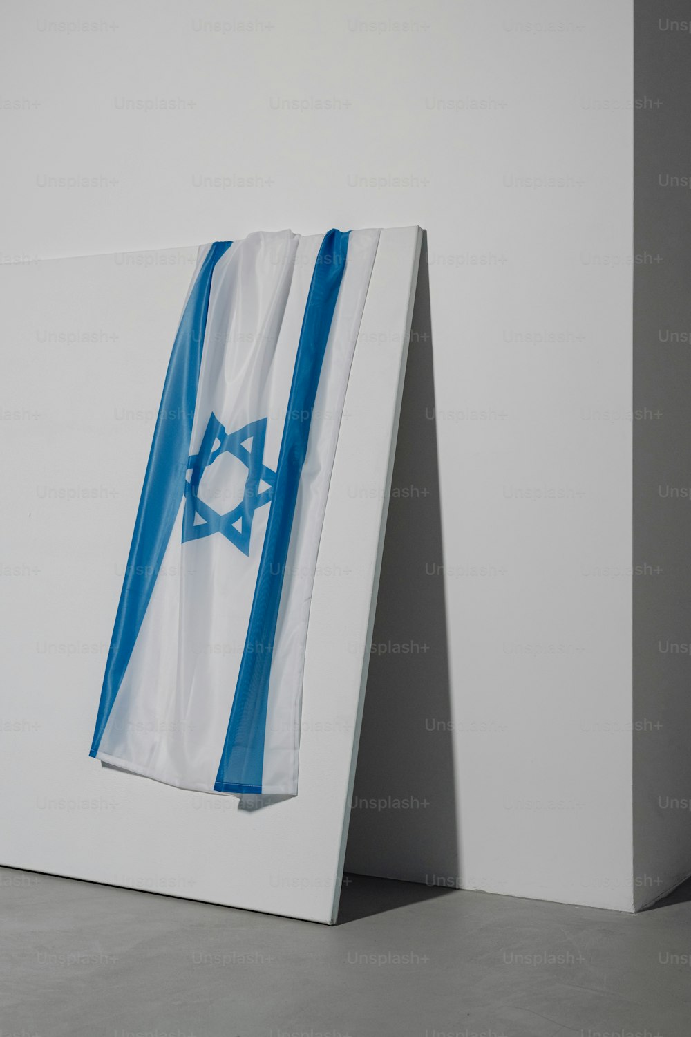 a blue and white flag hanging on a white wall