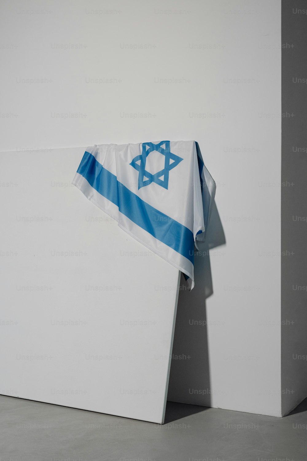 uma bandeira israelense pendurada em uma parede branca