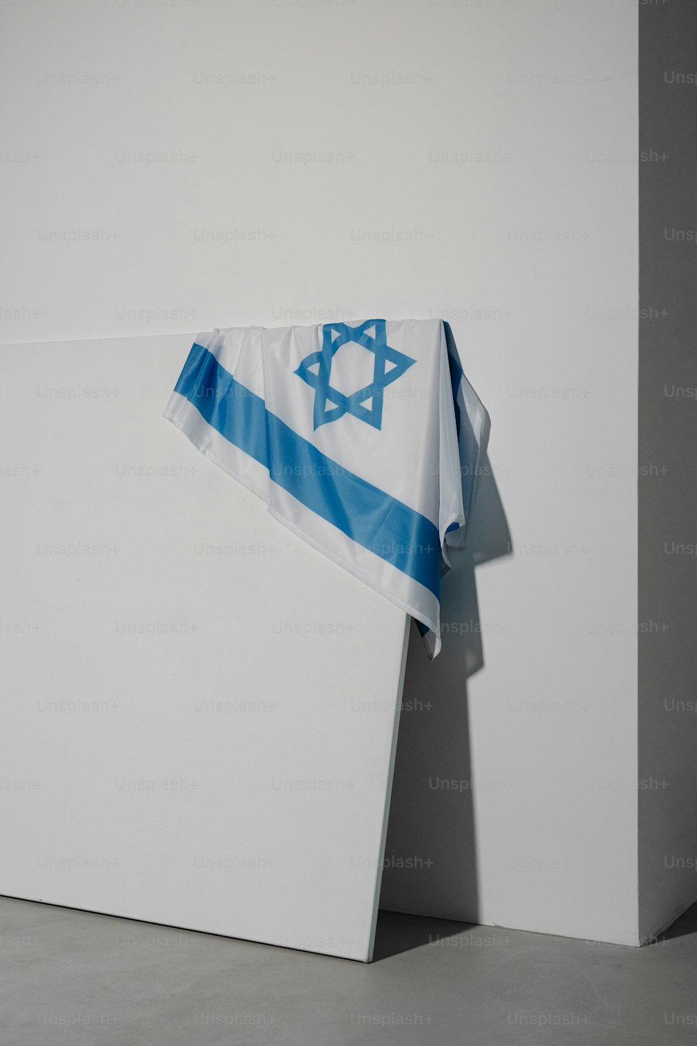 Un drapeau israélien accroché à un mur blanc