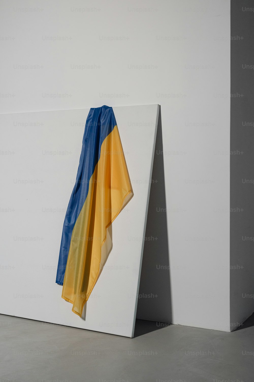 a blue and yellow scarf hanging on a white wall