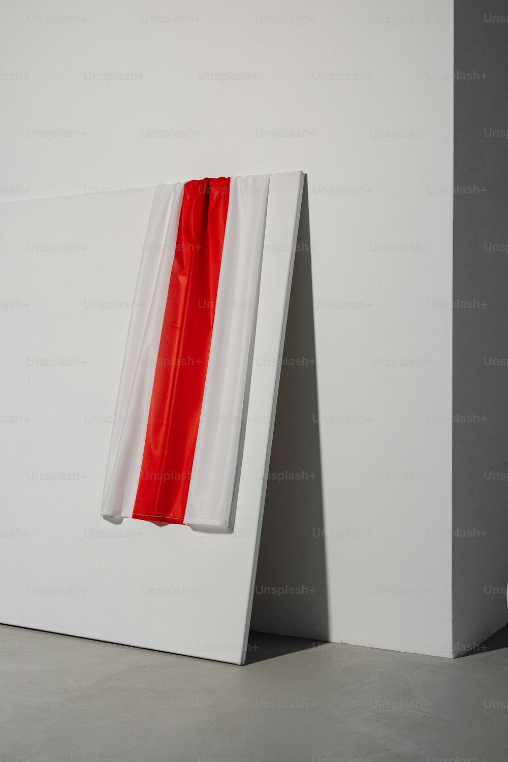 a red and white piece of artwork on a white wall