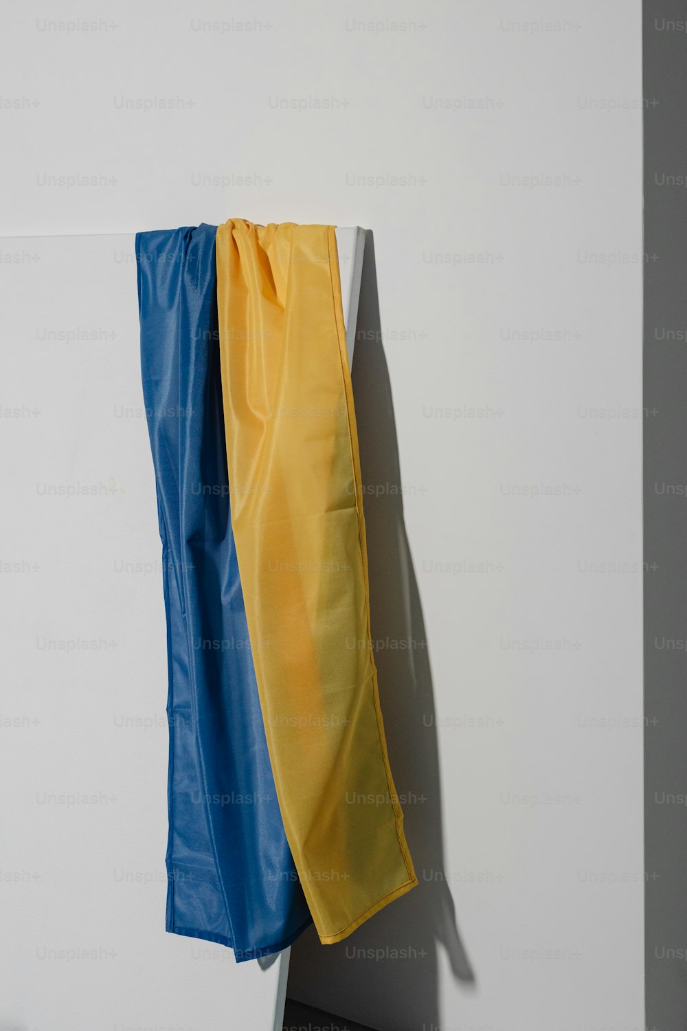 a yellow and blue piece of cloth hanging on a wall