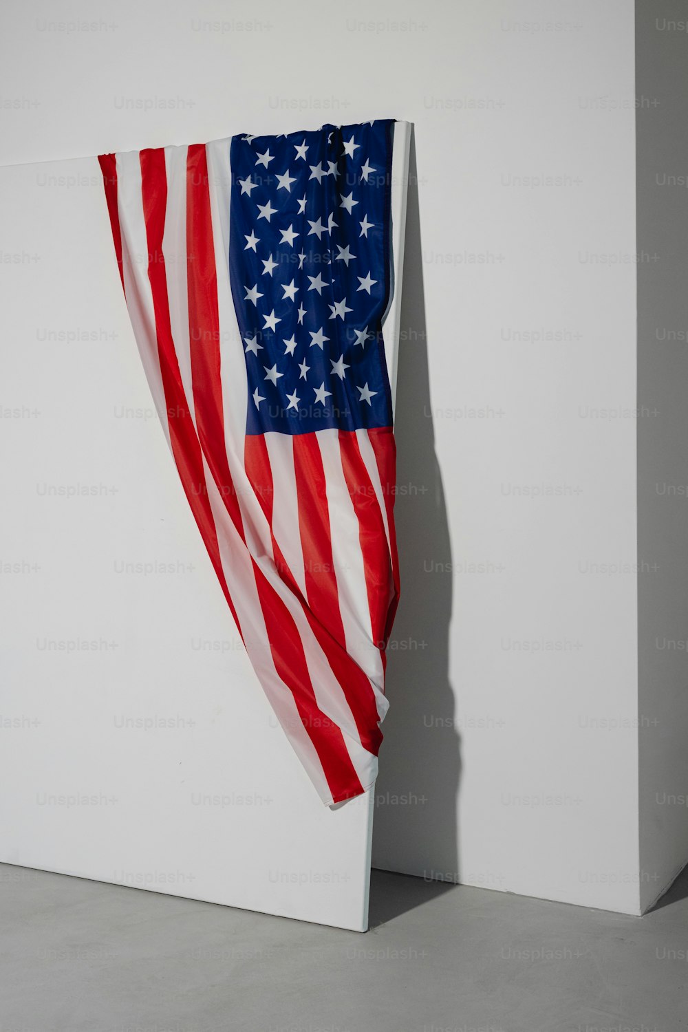 Un drapeau américain accroché à un mur blanc