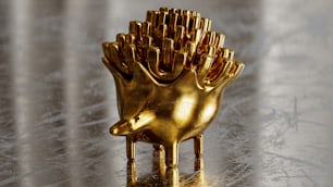 a golden sculpture of a hedgehog on a shiny surface
