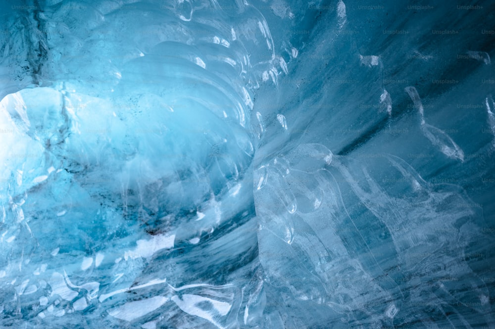 a large ice cave with a man standing inside of it