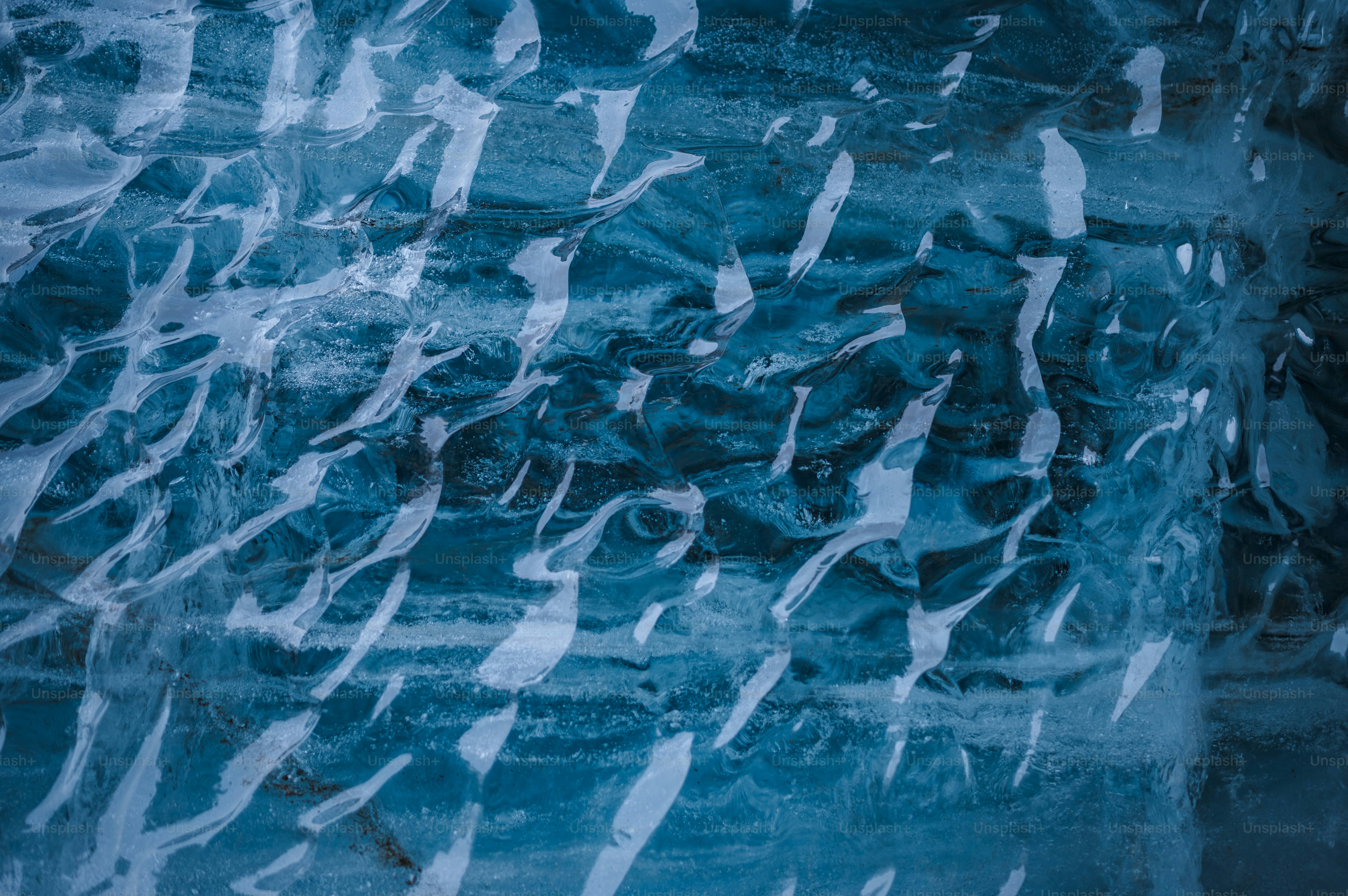 a wall covered in ice and snow next to a street