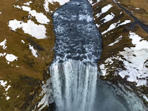 an aerial view of a waterfall with snow on the ground