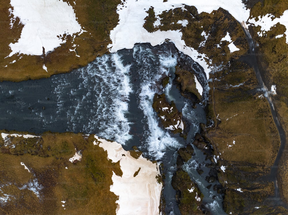 an aerial view of a body of water surrounded by snow