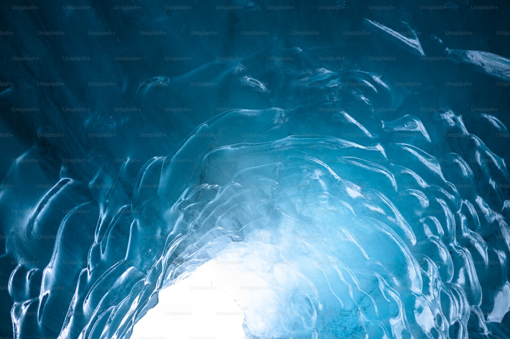 a large ice cave with a bright light coming through it