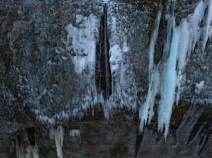 a close up of ice and water on a rock