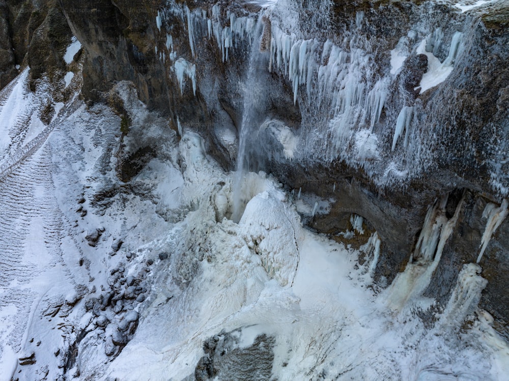 an aerial view of a frozen waterfall in the mountains