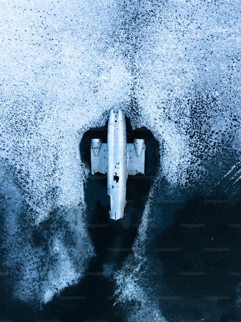 an aerial view of a jet flying over the ocean