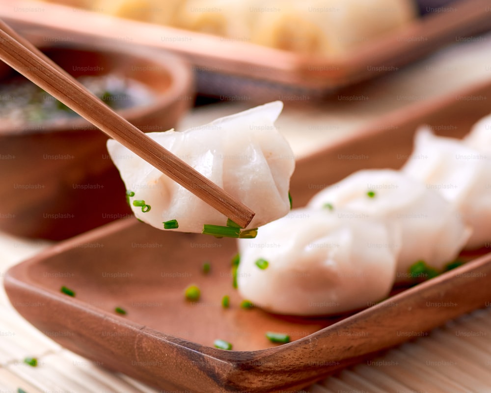 a plate of dumplings with chopsticks sticking out of them