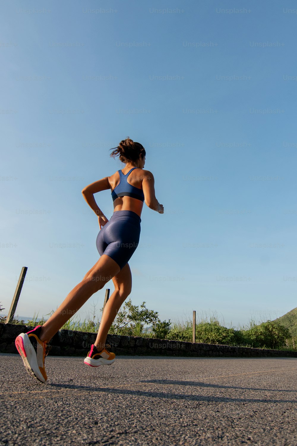 a woman running on a road with a sky background