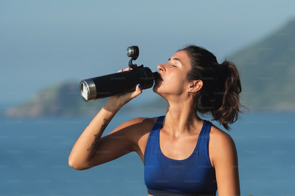 a woman drinking water from a water bottle