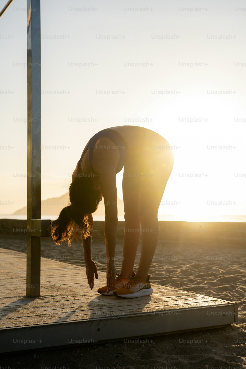 a woman doing a handstand on a dock