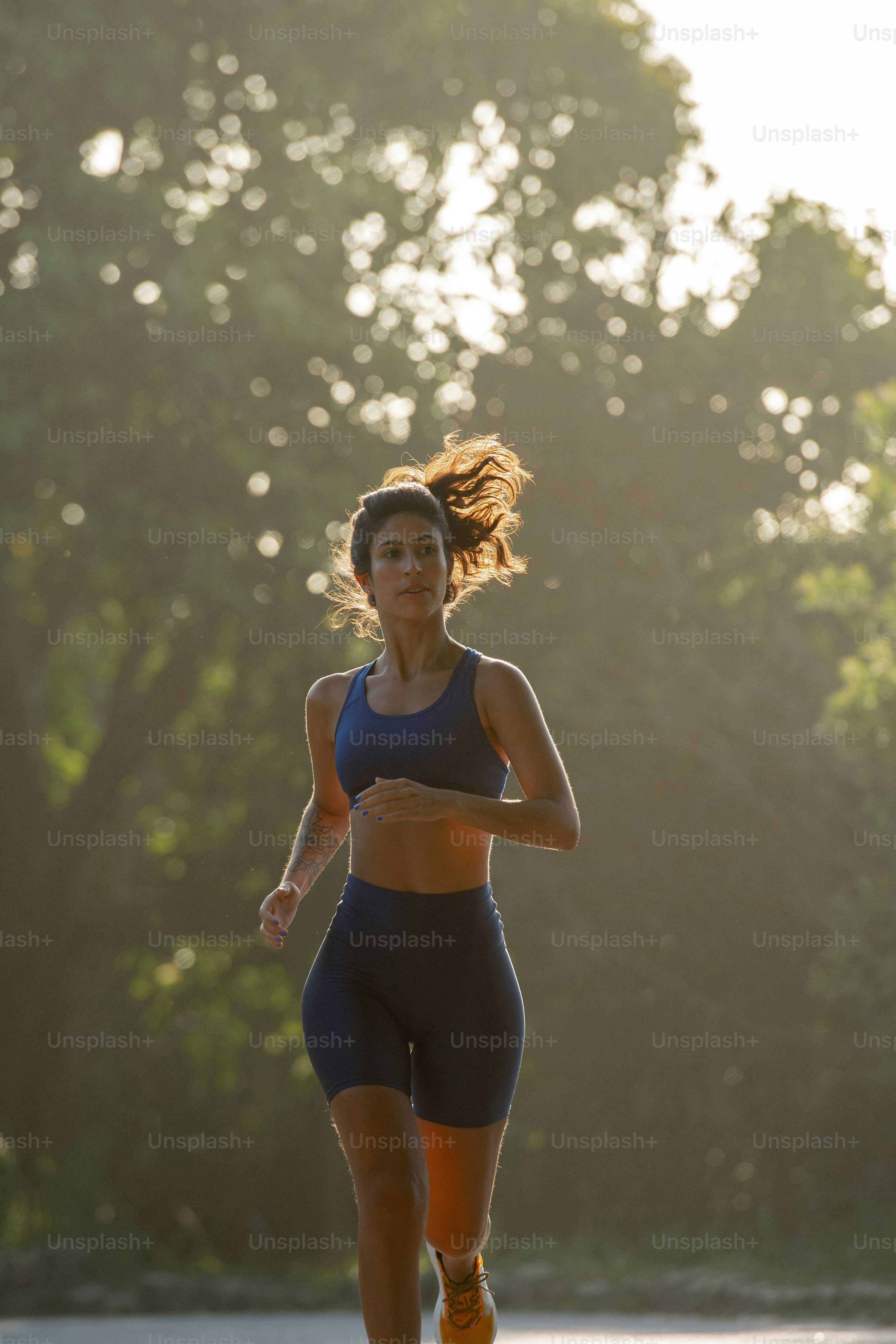 A woman running down a road next to the ocean photo – Motivational ...