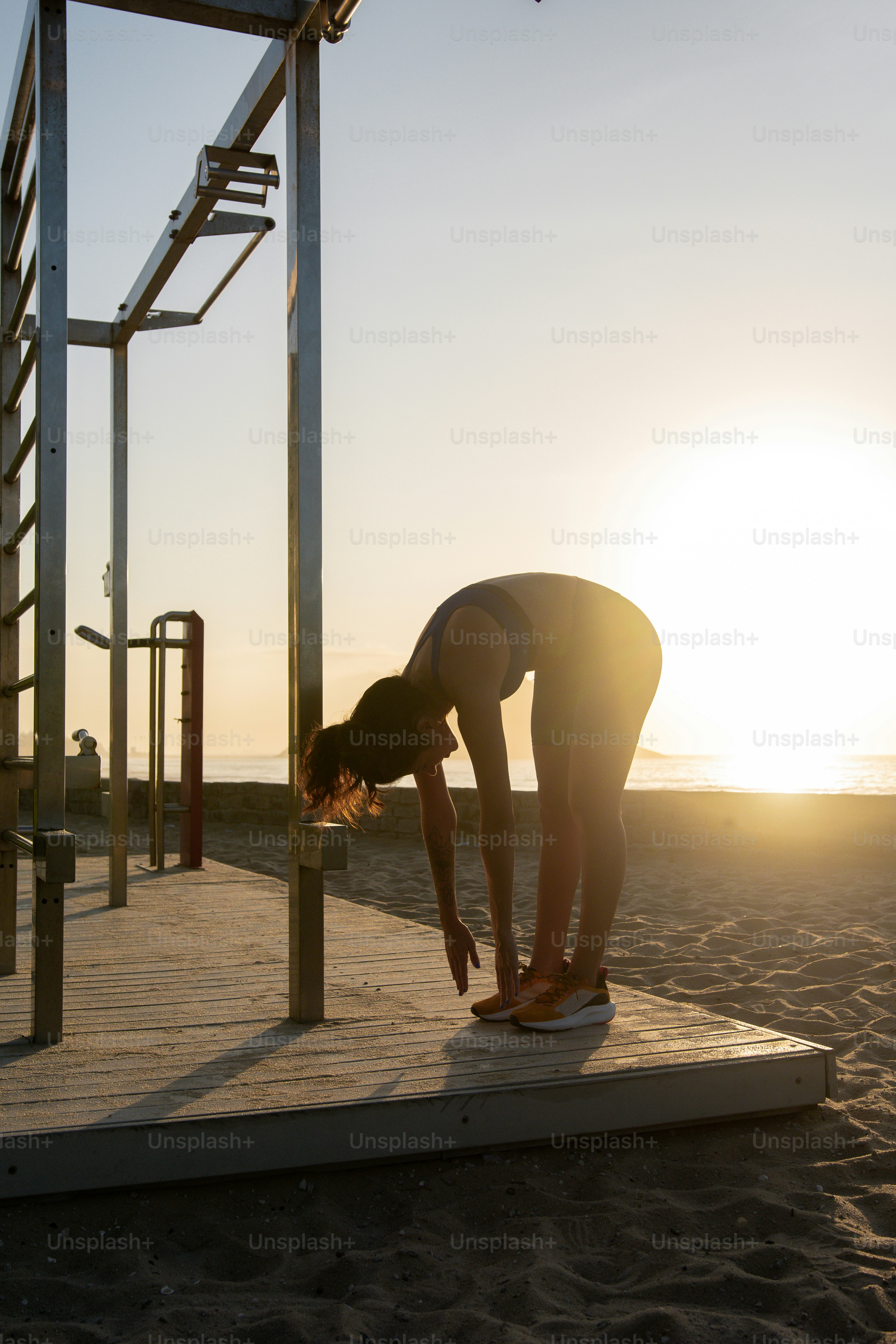 a woman doing a handstand on the beach