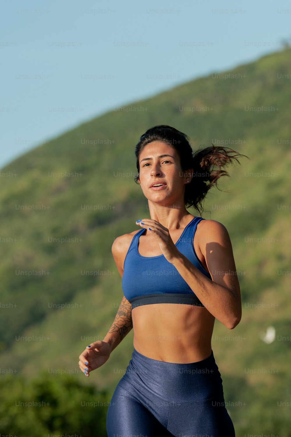 a woman running in a blue sports bra top