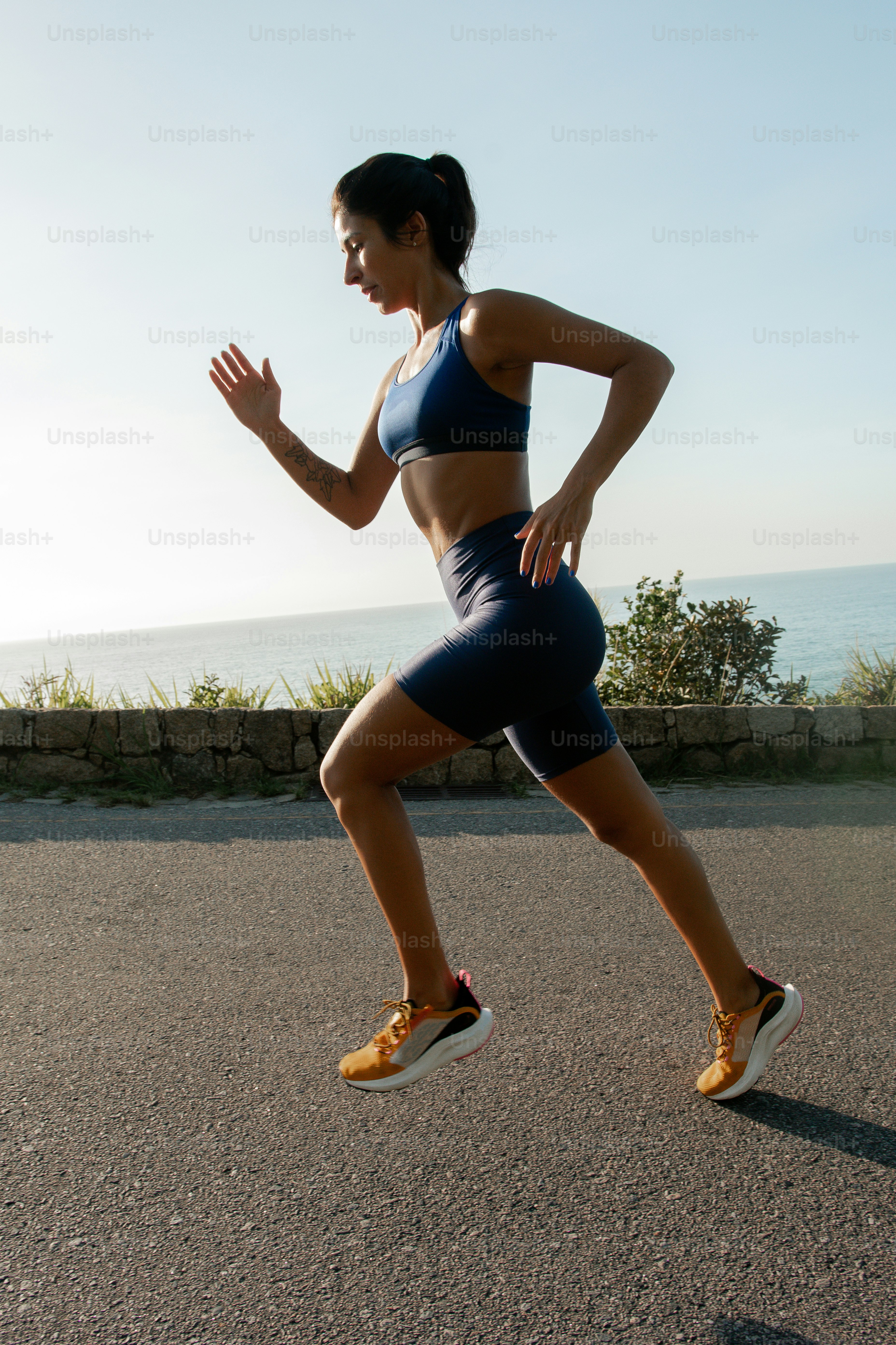 A woman running on a road near the ocean photo – Motivational Image on ...