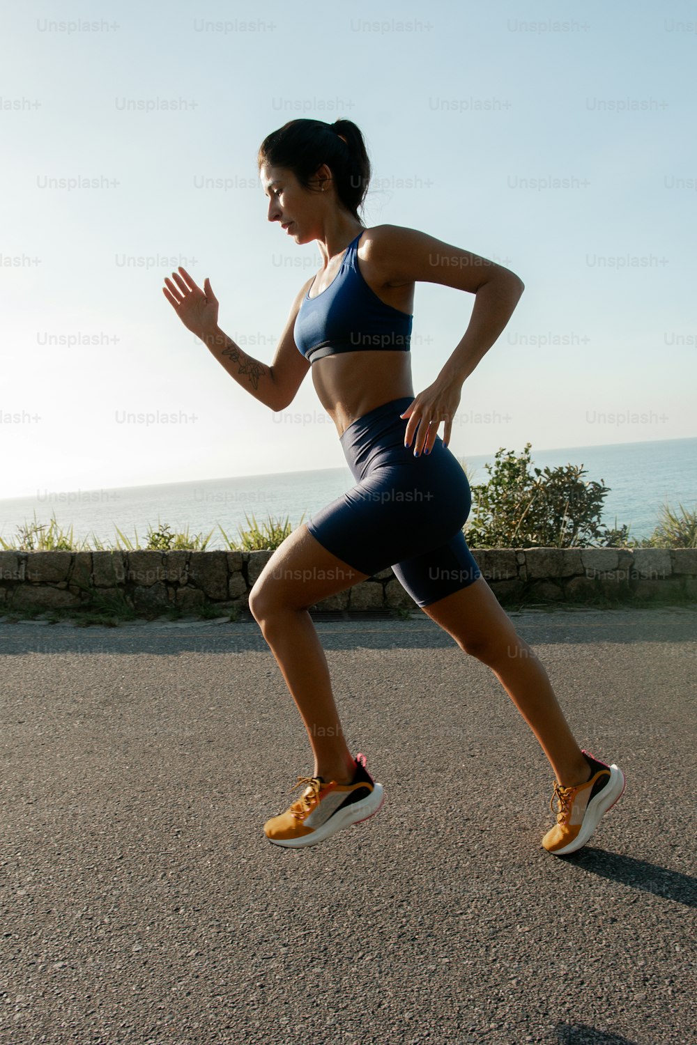 Eine Frau rennt auf einer Straße in der Nähe des Ozeans