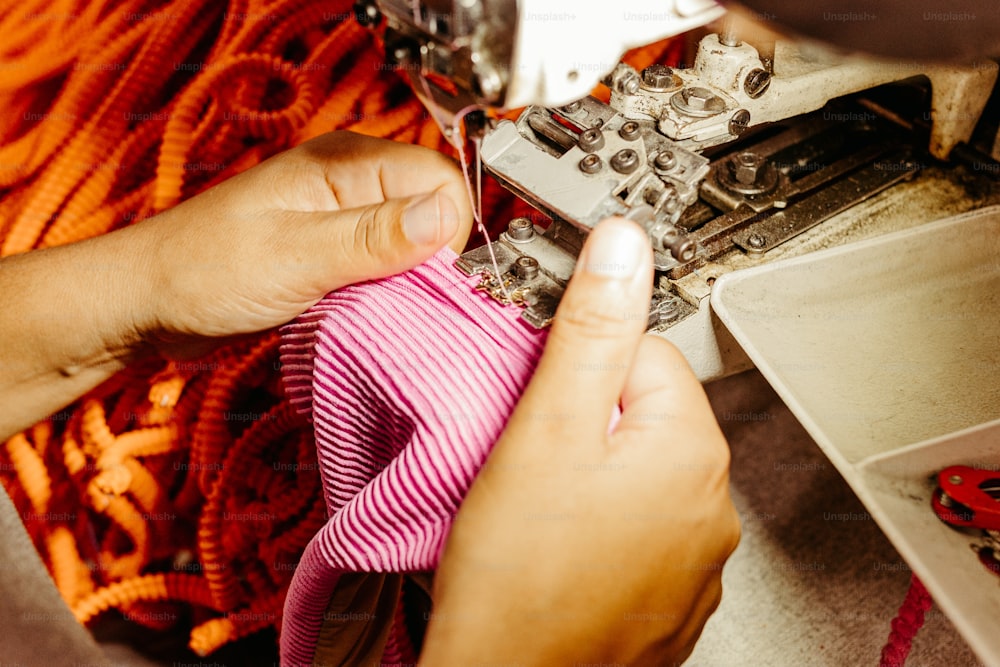Una mujer está trabajando en una máquina de coser