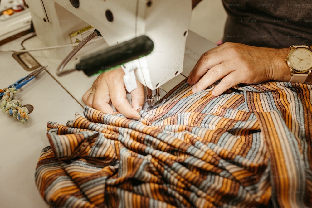 una persona che usa una macchina da cucire per cucire una camicia