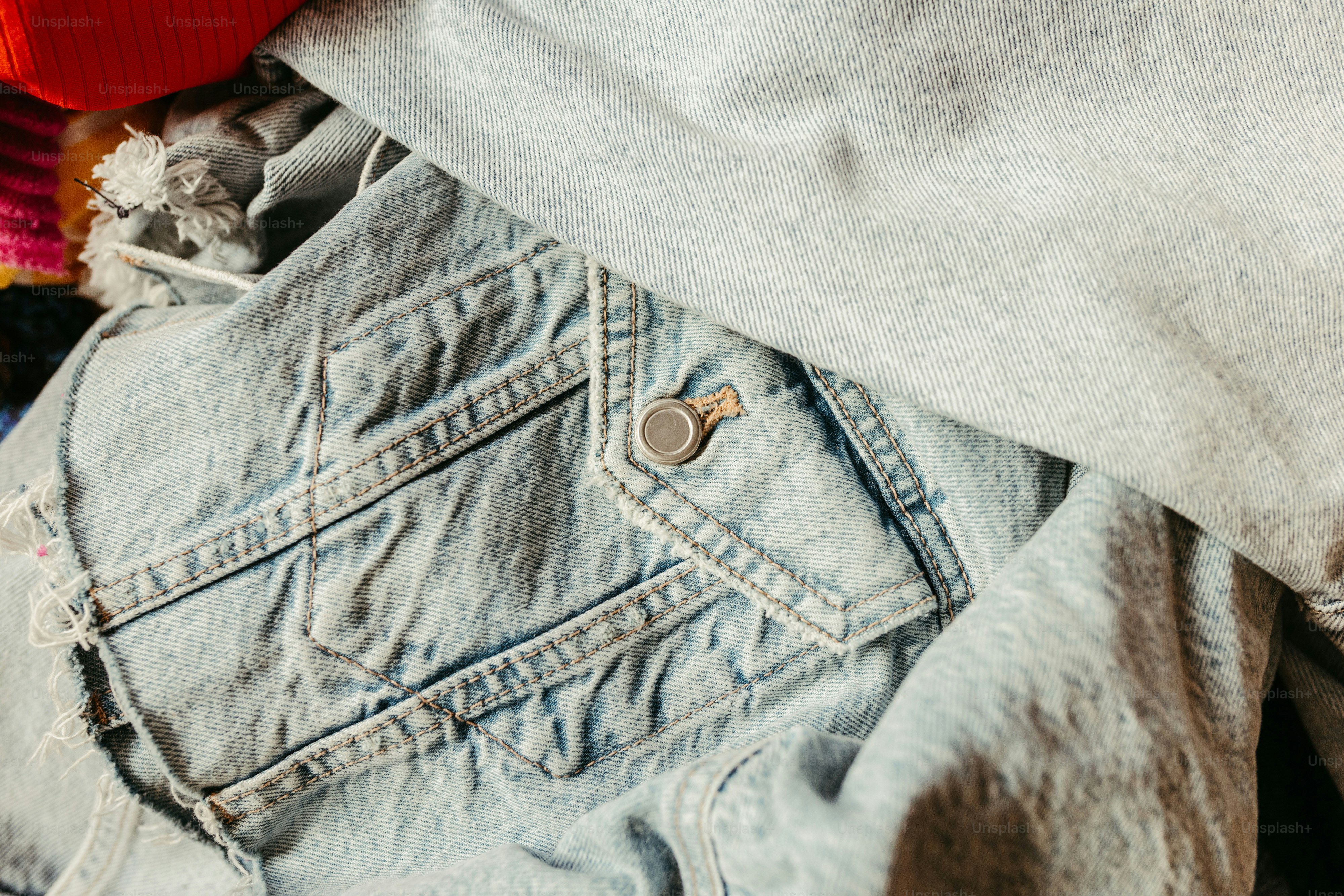a close up of a pair of jeans and a red hat