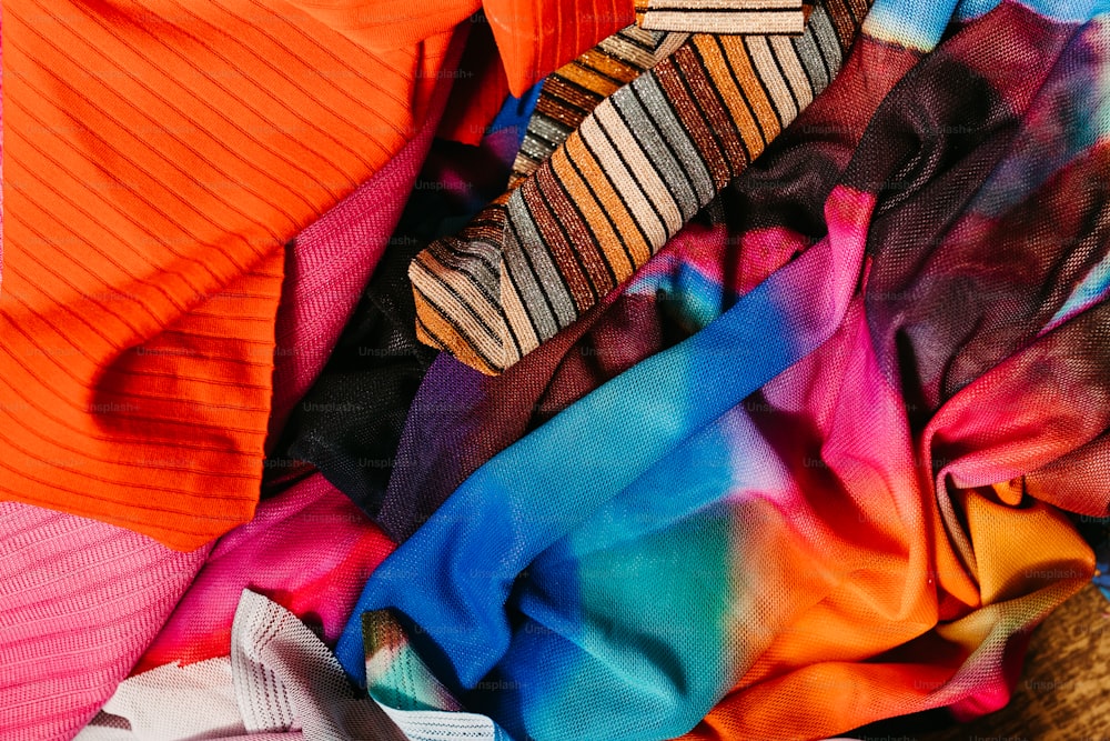 uma pilha de roupas de cores diferentes sentadas uma ao lado da outra