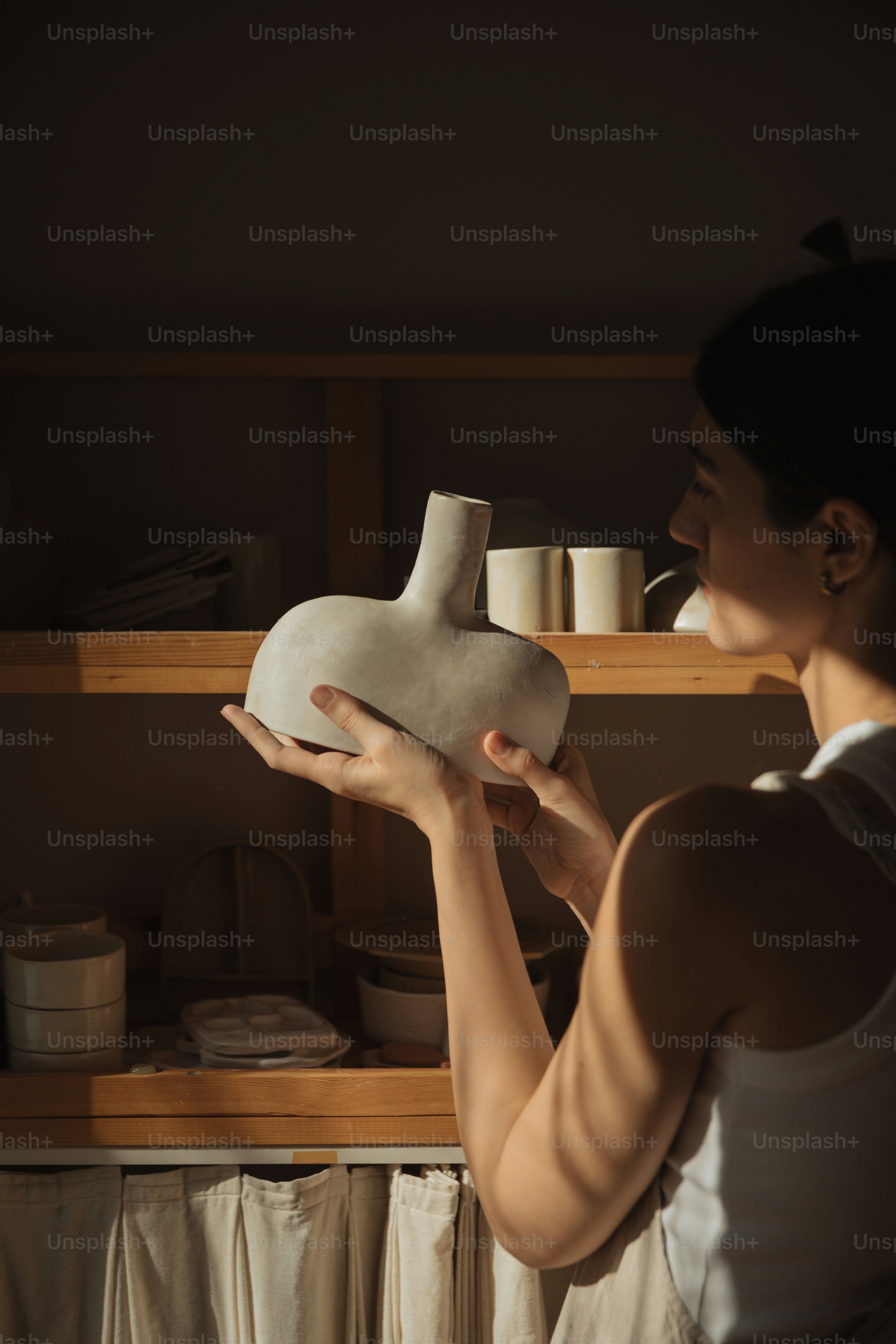 uma mulher está segurando um vaso em suas mãos