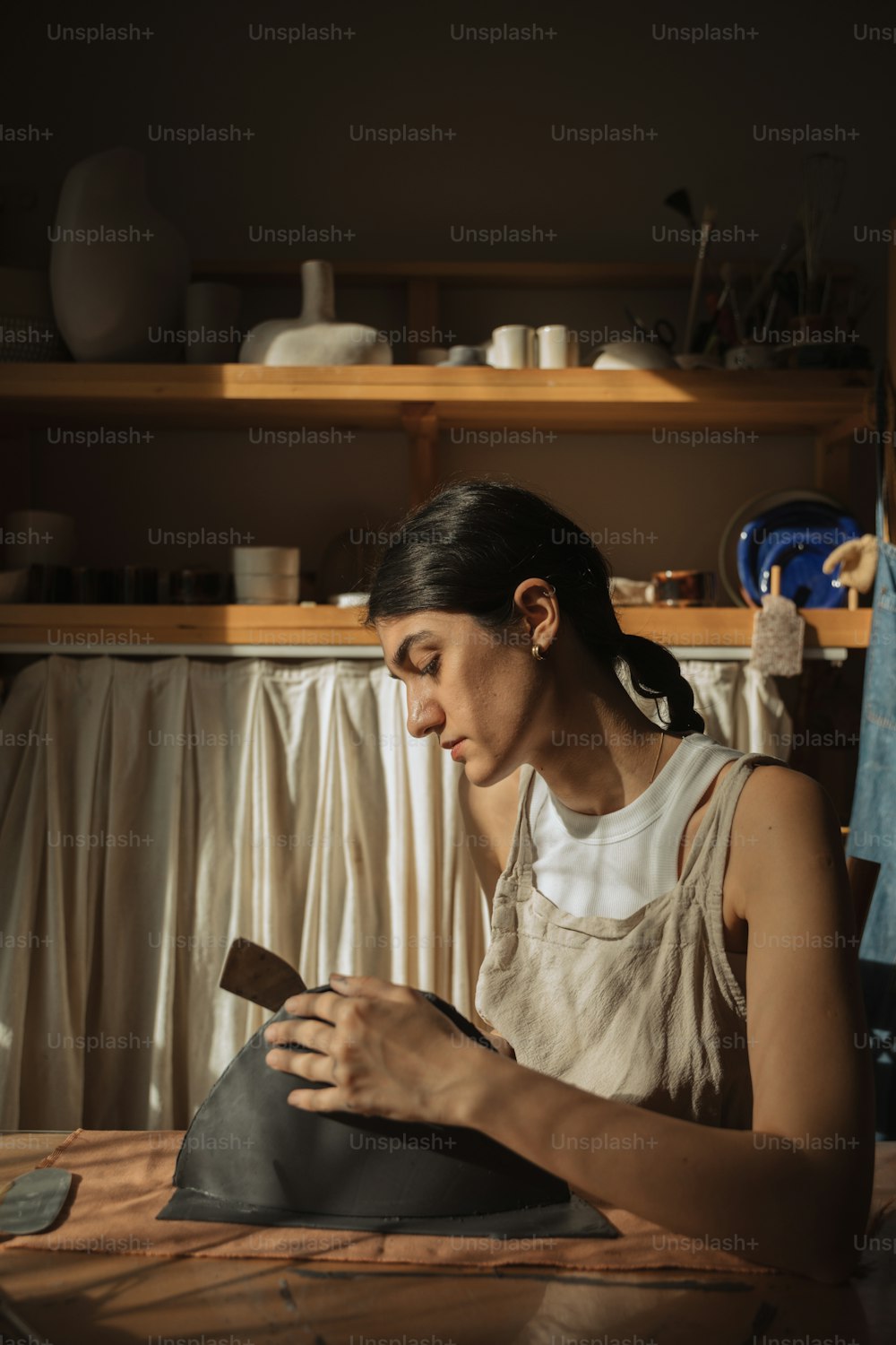 a woman working on a piece of pottery