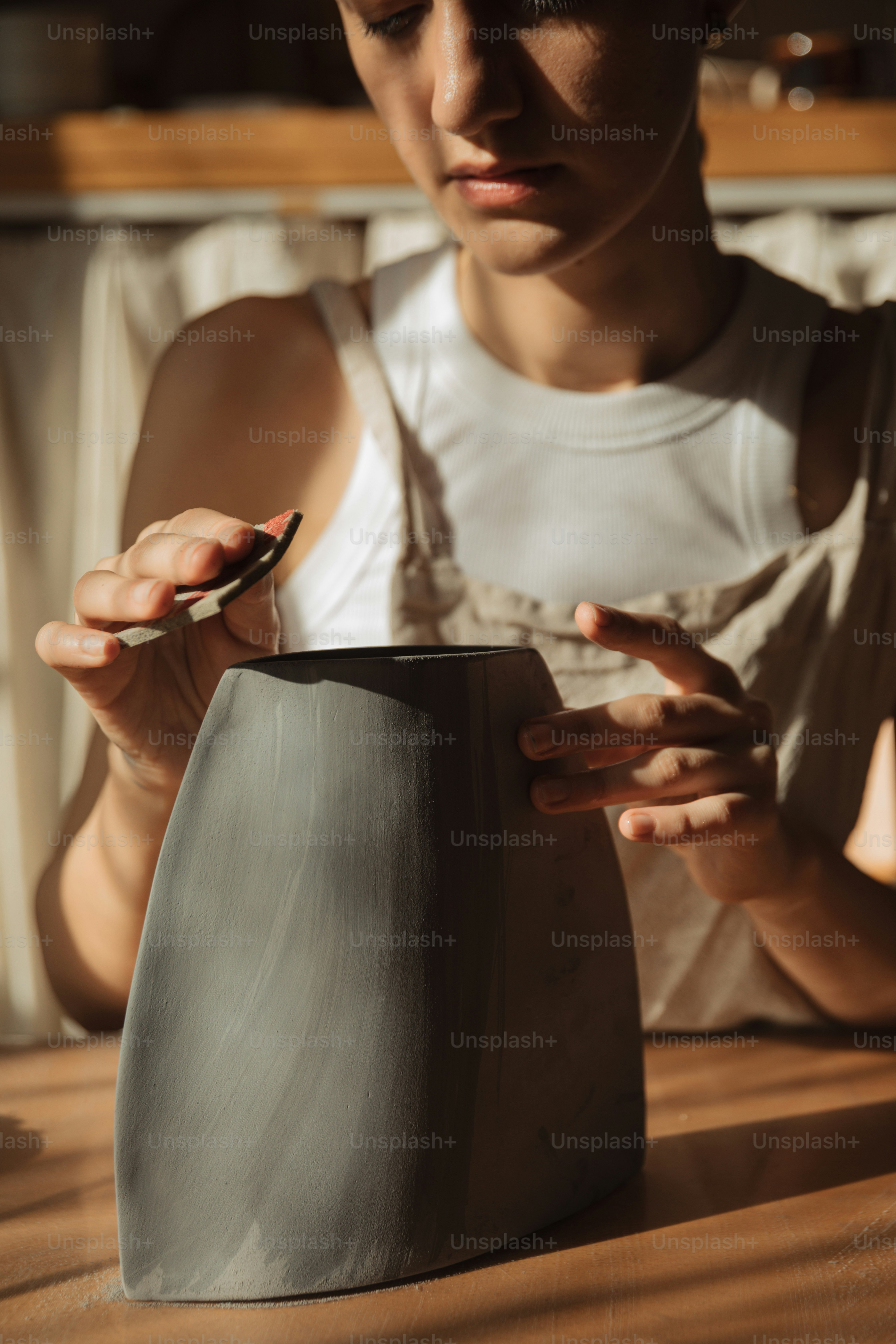 uma mulher está fazendo um vaso de barro