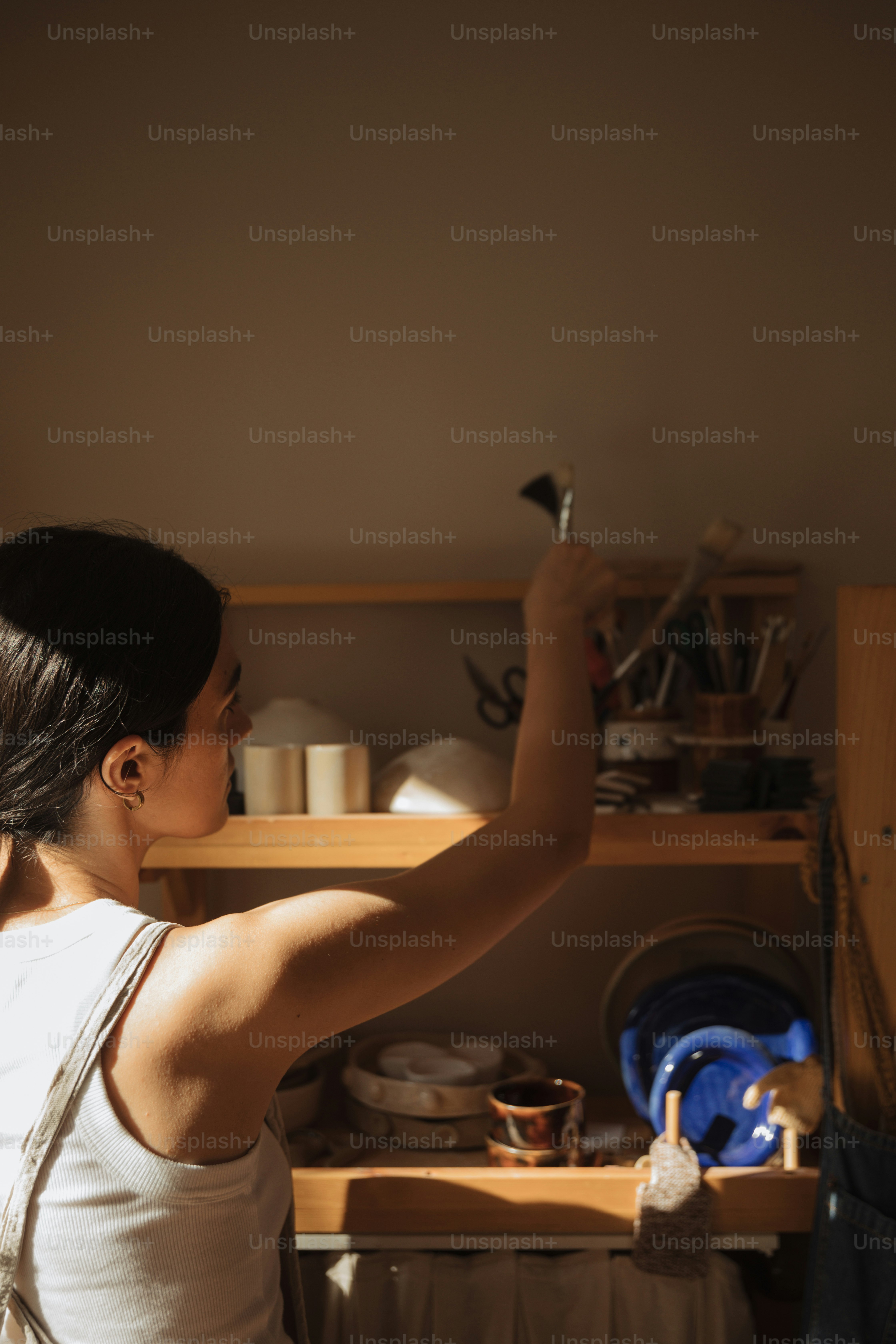 uma mulher em uma regata branca está alcançando algo