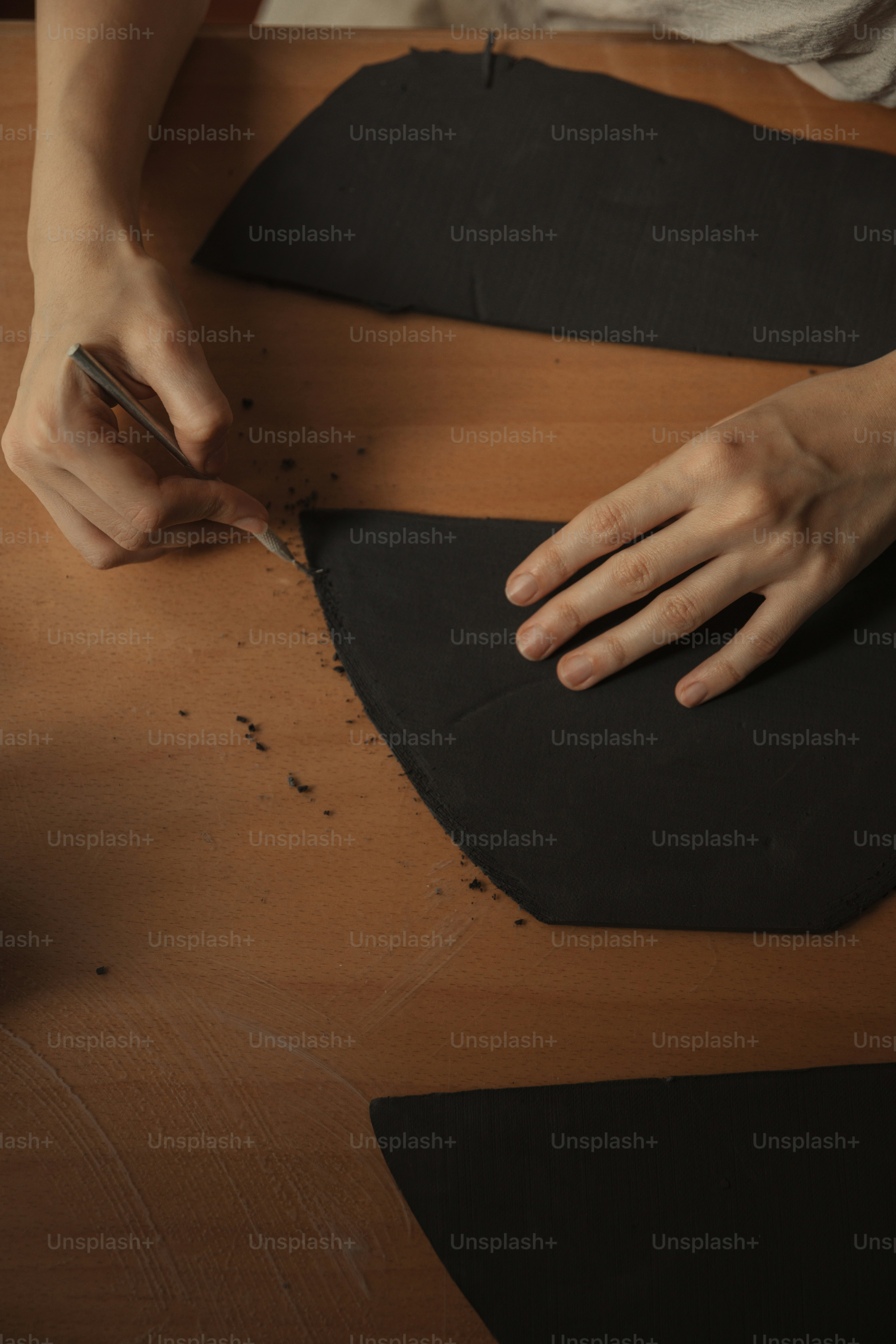 uma pessoa cortando um pedaço de papel preto