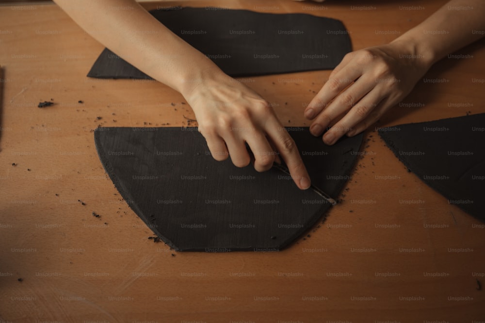 a person is cutting up a piece of black material