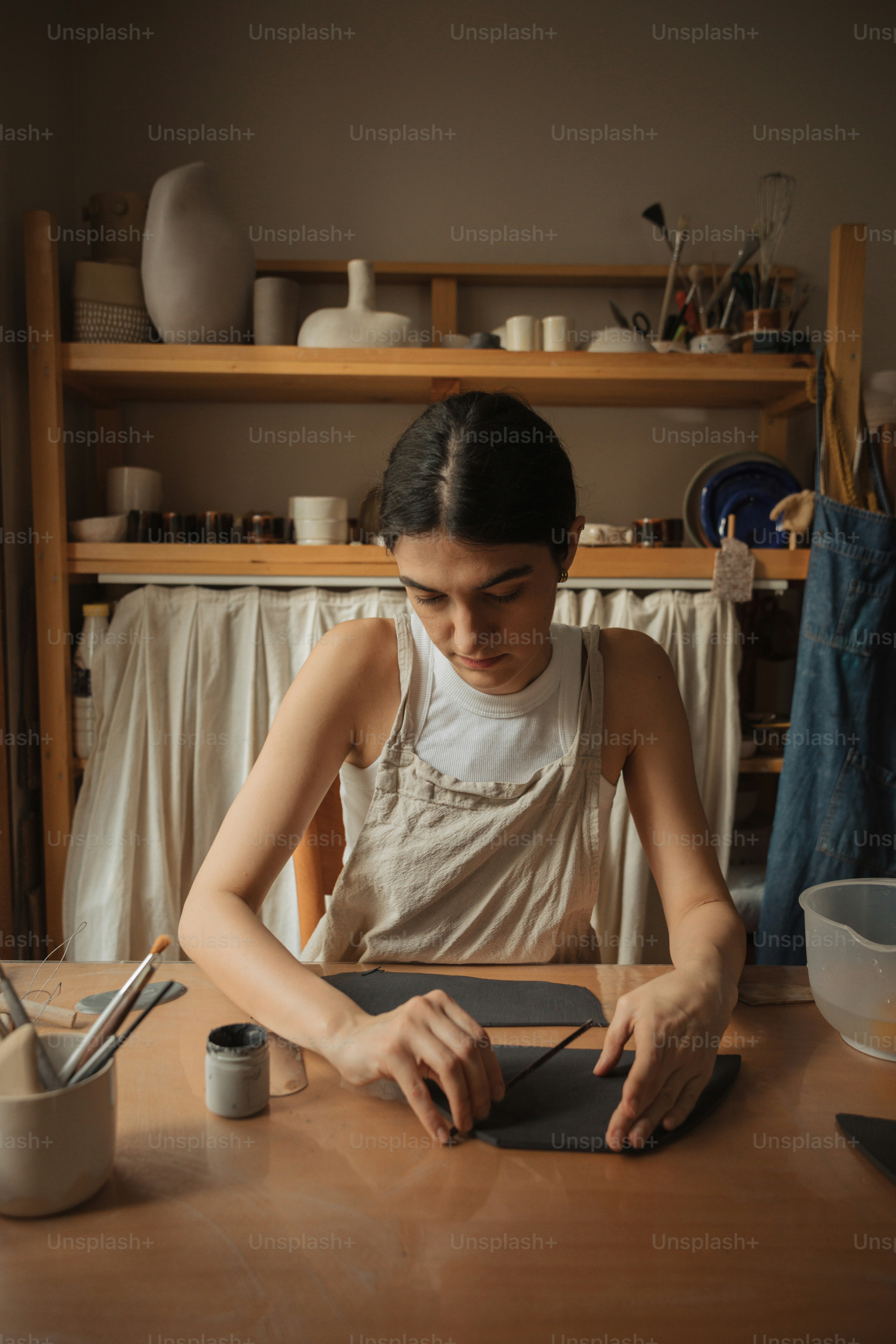 uma mulher sentada em uma mesa usando um comprimido