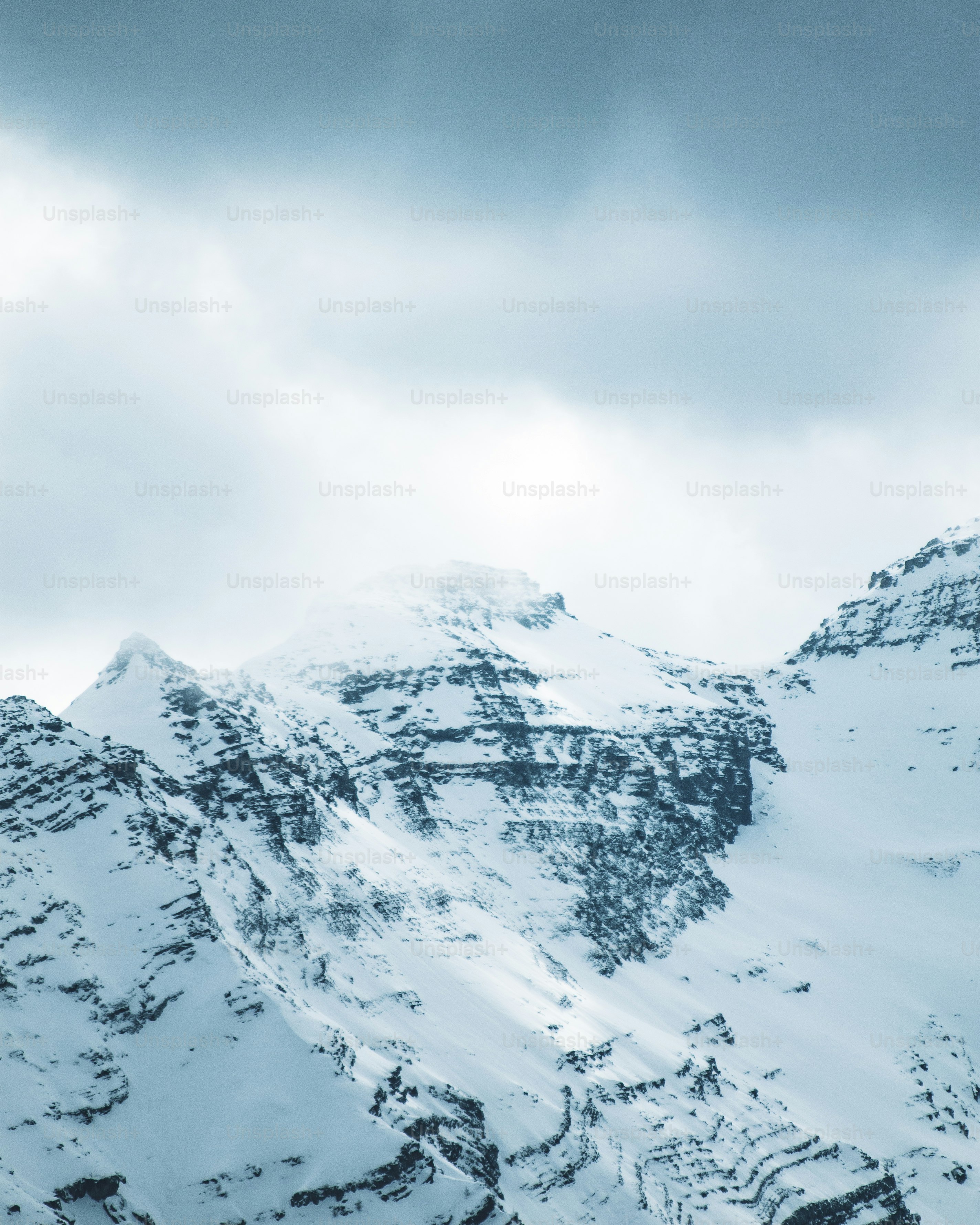 ein schneebedeckter Berg unter einem bewölkten Himmel