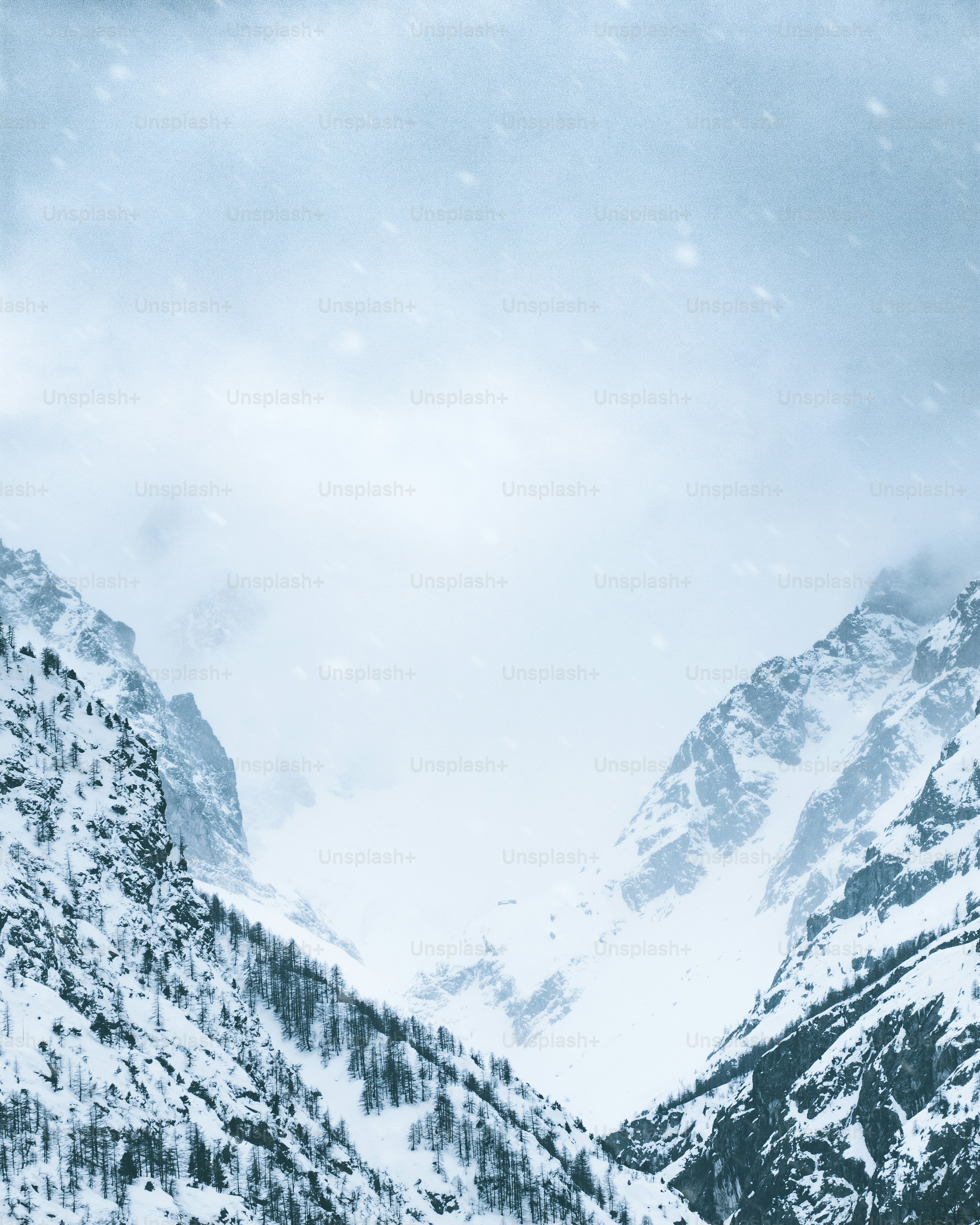 eine schneebedeckte Bergkette mit ein paar Skifahrern