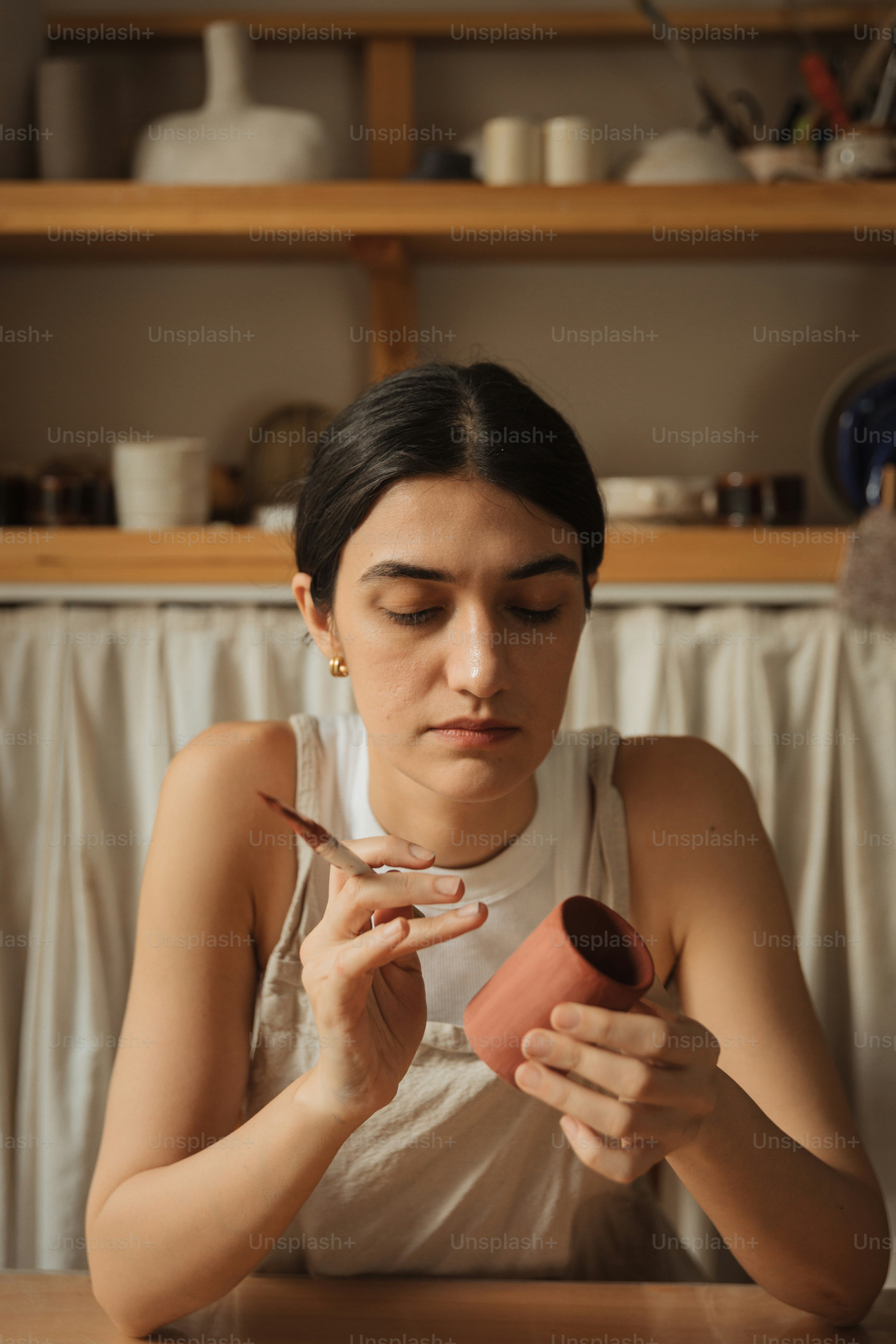 Una mujer sentada en una mesa sosteniendo un pedazo de papel